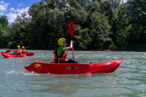 Ragazzo che pagaia sul kayak sul fiume Adda