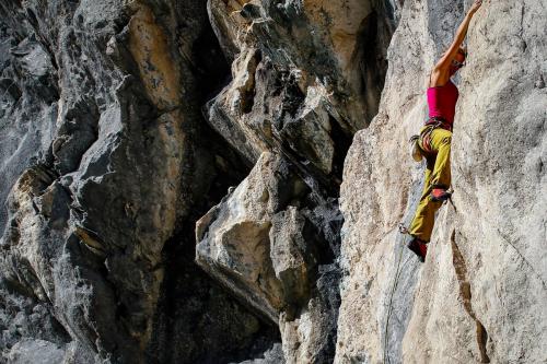 Ragazza che si arrampica su roccia in Valtellina