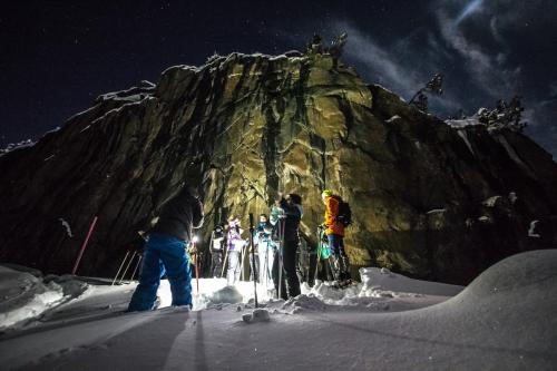 Delle persone durante una ciaspolata al chiaro di luna con guida alpina in Valtellina