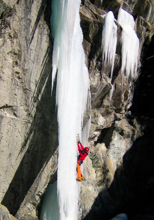 Uomo che sta scalando una cascata di ghiaccio