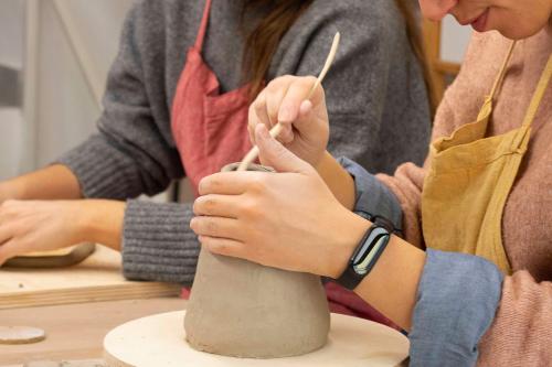 Ragazze che partecipano al workshop di ceramica in gres per principianti a Milano in Lombardia