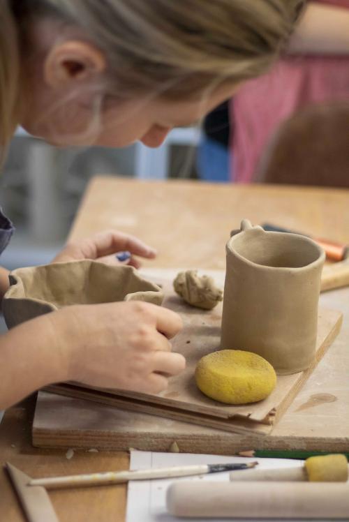 Una ragazza mentre realizza un vaso in ceramica durante il workshop a Milano in Lombardia