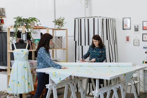 Due giovani ragazze si trovano in un laboratorio artigianale mentre stanno partecipandoi al corso per imparare a cucire una gonna con elastico a Milano in Lombardia