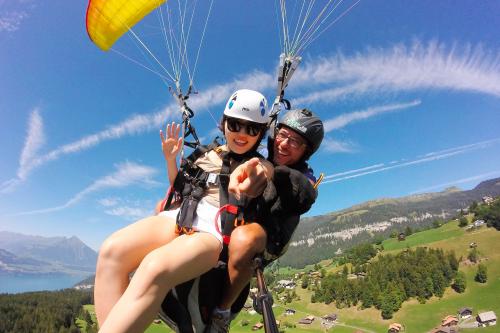 Due ragazzi felici durante una discesa in parapendio biposto vicino a Bergamo in Lombardia